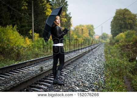 Girl, Umbrella And Rails In Autumn Day