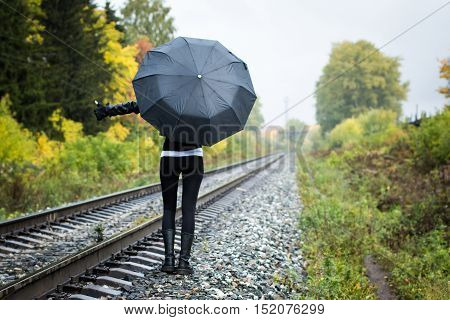 Girl, Umbrella And Rails In Autumn Day