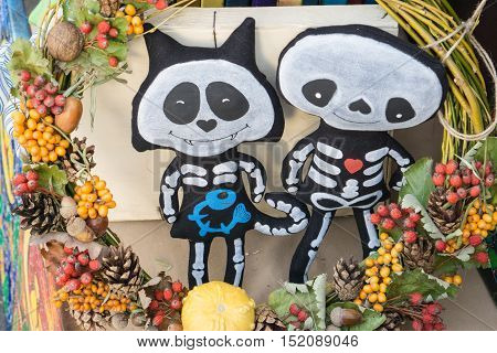 very cute handmade dolls of a cat kitty with friend made for helloween with whreas circlet made of different fruits berries nuts pinecones pumpkin