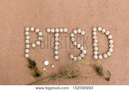 picture of a PTSD text with herbal pills on a wood background