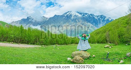 The wide and quiet forest glade with the huge mountains on the background is the perfect place to enjoy the sounds of nature and forget about the stress Kazbegi National Park Georgia.