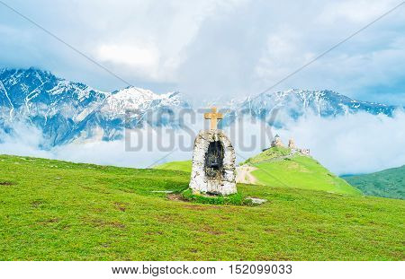 It's often getting foggy in the evening in mountains Gergeti Trinity Church is still seen in front of the massive cloud formation Kazbegi National Park Georgia.