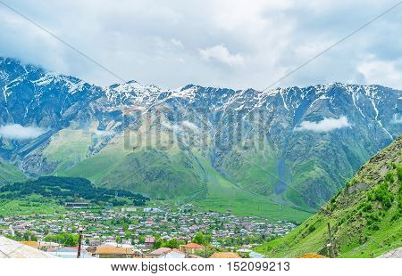 The famous Georgian mountain resort of Stepantsminda located in the mountain valley at the slopes of Kazbegi National Park Georgia.