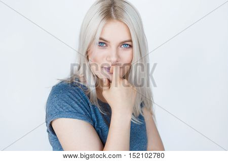 Closeup portrait of a sensual young blond woman over white background. Teenage girl with blue eyes and bleached silver hair