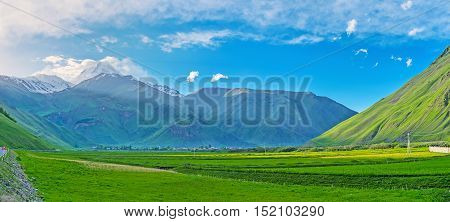The sun hides behind the mountains and the Sno valley becomes shady long before the sunset Kazbegi Georgia.