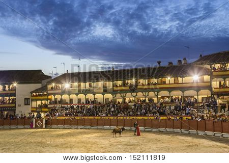 Chinchon Spain - October 15 2016: Plaza square Mayor of Chinchon adapted as a bullring Detail of balconies illuminated dressed with the Spanish flag beautiful sunset at Chinchon Spain