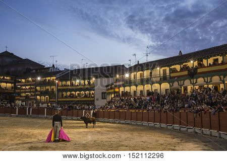 Chinchon Spain - October 15 2016: Plaza square Mayor of Chinchon adapted as a bullring Detail of balconies illuminated dressed with the Spanish flag beautiful sunset at Chinchon Spain