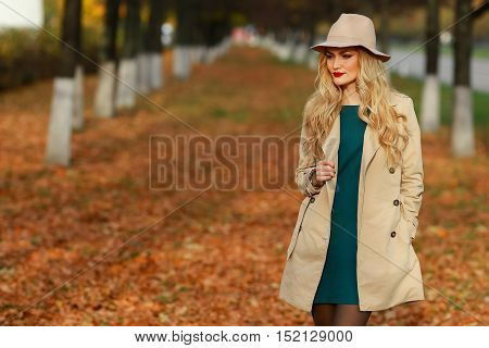 Beautiful woman in autumn park. ellow maple garden background. looking to the left of the frame towards blank copy space.