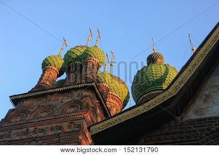 old beautiful red-brick Russian Orthodox Church with its green domes of the 16th century in Yaroslavl