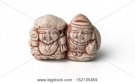 Netsuke of two fishermen with their catch. Isolated. A miniature sculpture which was used as a button-like trinket in traditional Japanese clothes kimono kosode which was devoid of pockets.