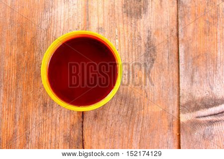 A cup with a hot drink on a wooden table outdoors