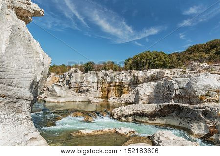 At the foot of the hill on which La Roque sur Cèze in France lies swirl spectacular waterfalls and rapids of the Cascades du Sautadet.