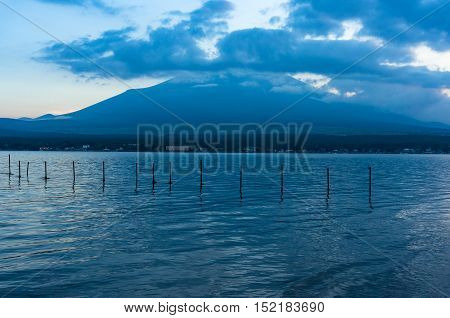 Mount Fuji on dusk with lake Yamanaka with fishing nets on the foreground. Lake Yamanaka popular tourist destination for Mount Fuji the highest mountain in Japan. Honshu Yamanashi prefecture Japan