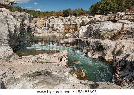 Young woman is paddling in the river Ceze at Cascades Du Sautadet in France.