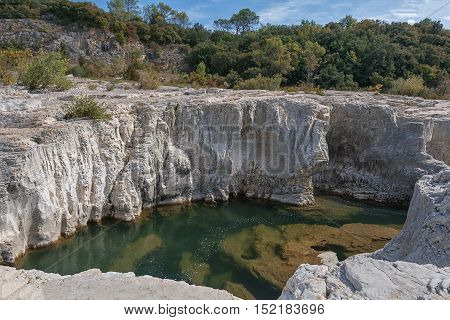 At the foot of the hill on which La Roque sur Cèze in France lies swirl spectacular waterfalls and rapids of the Cascades du Sautadet.