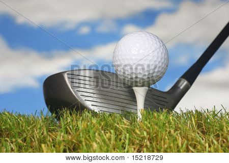 Ready to drive a golf ball with grass and sky.