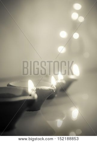 Diwali Greeting card background. Monochromatic image of glowing traditional Indian lamps. 