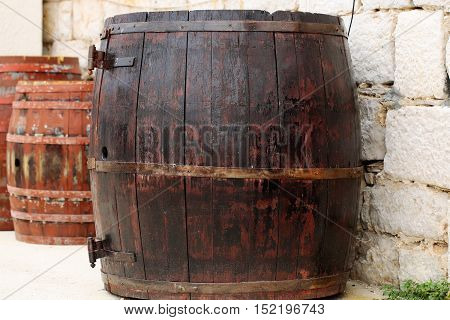 Wine barrels traditional oak wood casks tierces hogsheads coopered wooden containers closed with corks on stone wall background