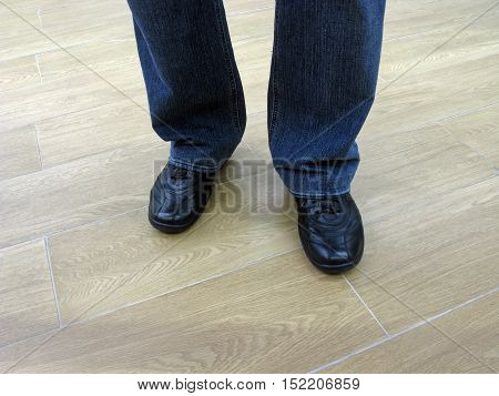 Man stands in jeans and in casual shoes. Man in jeans and everyday shoes. Man in jeans and casual shoes. Male legs in jeans and boots.