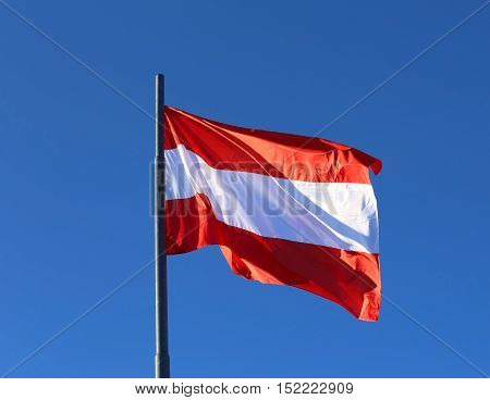 Austrian Flag Waving In The Blue Cloudless Sky