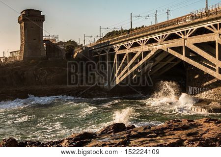 Tower on Promontory near Shore Line and Waves Crashing on Rocky Shore