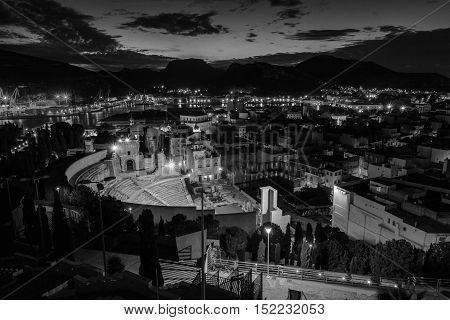 Aerial view of port city Cartagena in Spain with famous roman amphitheater. Beautiful sunset over the mountains. Black and white