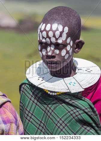 AFRICA, KENYA, MAY, 08, 2016 - African children with painted markings of face and with the traditional decoration of beads at Masai Mara National Park, Kenya, Africa