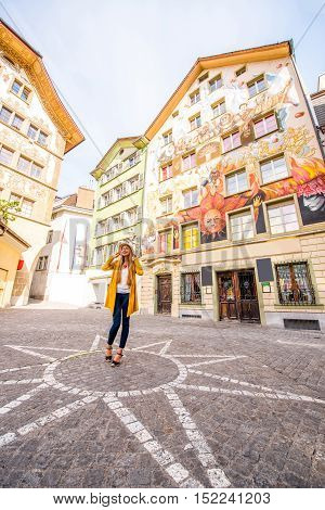 Young woman on the square with beautiful old buildings in the old town of Lucerne city in Switzerland