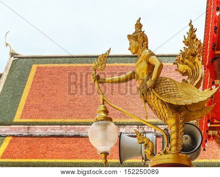 Lamps of Kinnari in Thailand on temple roof background