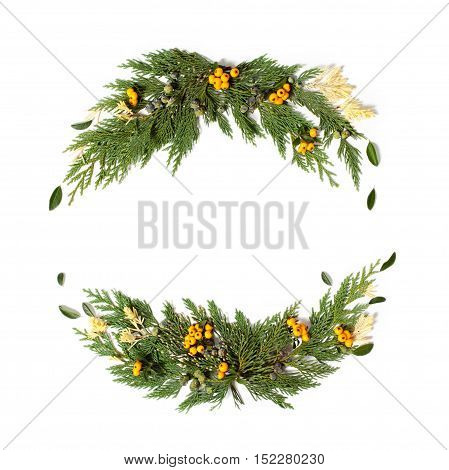 Christmas concept - frame wreath with evergreen Cupressus nootkatensis and Pyracantha red and yellow berries. Flat lay top view.
