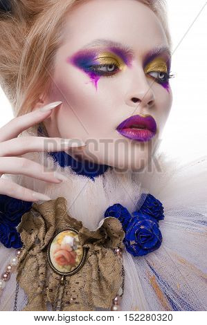 Studio beauty portrait of a girl with blonde hair wearing an undead makeup with purple eye shadows, purple lips and pale skin. Vampire queen halloween costume of a girl wearing a veil