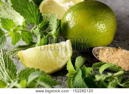 ngredients for making mojitos (ice cubes, mint leaves, sugar and lime on rustic background)