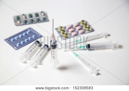Medicine pills or capsules with syringe on white background. Drug prescription for treatment medication. Pharmaceutical medicament. Injection with vaccine
