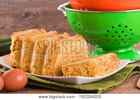 Vegetable meatloaf and ingredients on white dish.