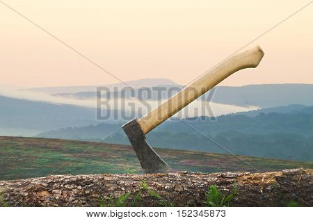 Axe in a log closeup.scenic mountain landscape