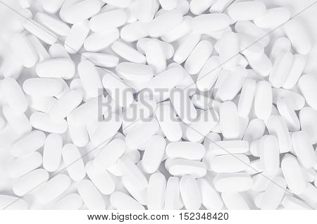 Heap of white pills on a white background Healthcare and Medicin