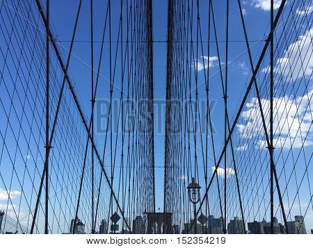 The symmetry of the Brooklyn bridge cable-stayed and buildings with blue sky, New York
