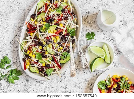 Mexican black bean salad. Salad with corn beans avocado and tortilla. On a light background top view