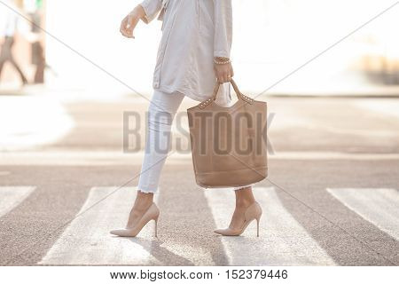 close up of woman legs walking on crosswalk. The woman is wearing shoes on high heels.