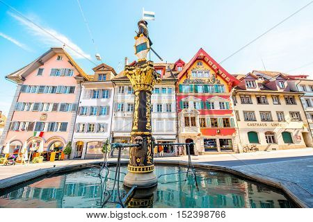 Zug, Switzerland - June 28, 2016: Fountain with colorful buildings on the central square in Zug town near Zurich city in Switzerland