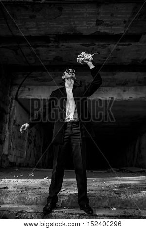 handsome guy in a white shirt and black coat throws newspaper