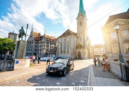 Zurich, Switzerland - June 28, 2016: View on Fraumunster church and Hans Waldmann monument with tourists and car in the old town of Zurich city in Switzerland
