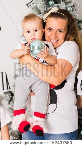 young mother with baby boy in front of xmas tree.