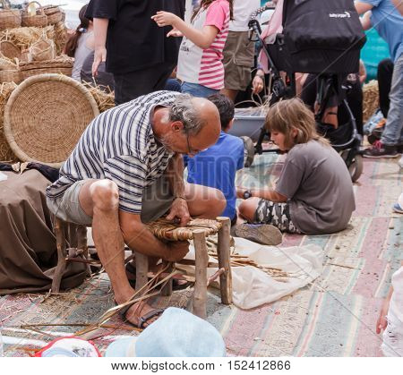 Elderly Man Weaves Chair At The Fair
