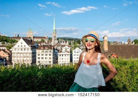 A portrait of a young female tourist on the beautiful old townscape background in Zurich city. Having a happy vacation in Switzerland