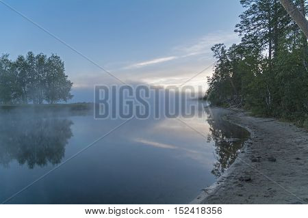 Foggy morning on the river. The fog creeps over the surface of the water. River Chirko-Kem Karelia Russia.