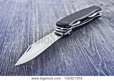 a pocket knife on the wooden desk