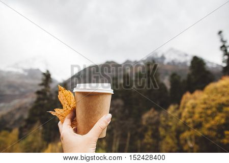 Drinking take away coffee in mountains. Fall trip. Rain weather. Freedom travel concept. Autumn weekend in forest.