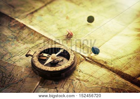 Old compass and mark on the map. Photos in a grunge style.