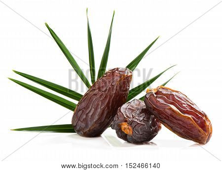 Close up of three big dates fruit with green leaf of palm tree isolated on white background.